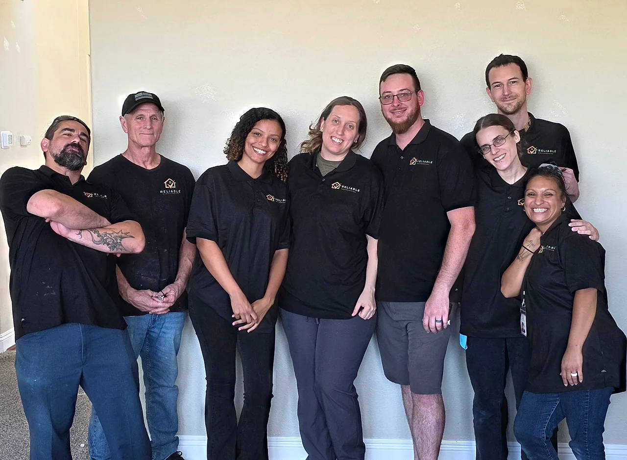 The Reliable Housekeeping team in branded uniforms — Paul, Nick, Andria, Charity, Brandon, Jacob, Kayla, and Angelica.